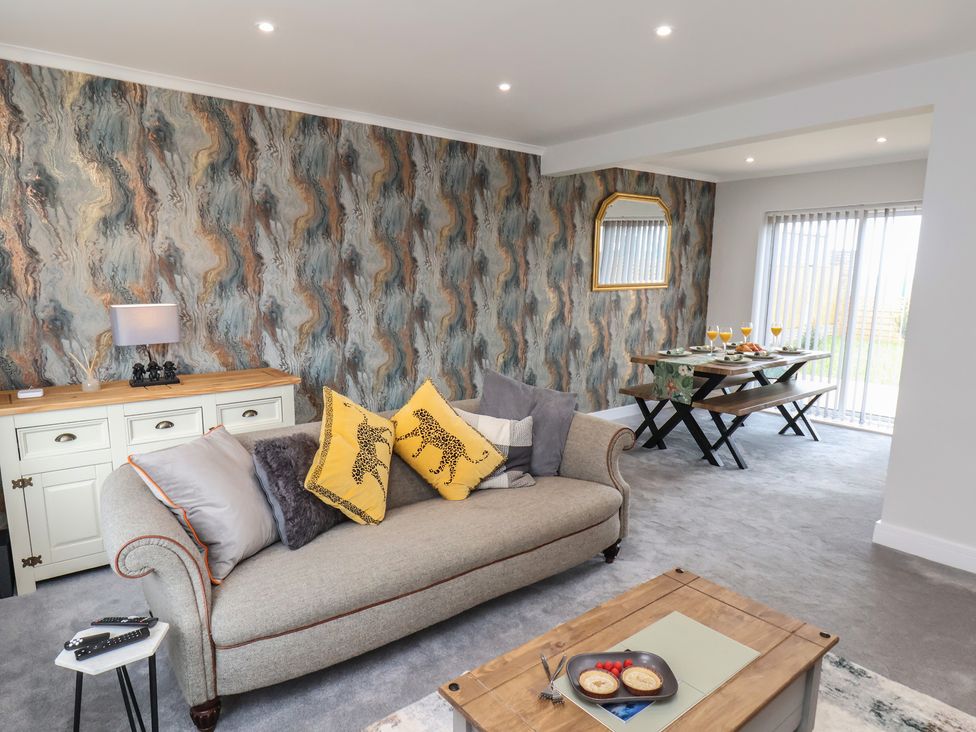A living room with a sofa and dining area at Sea View House in Marske-By-The-Sea