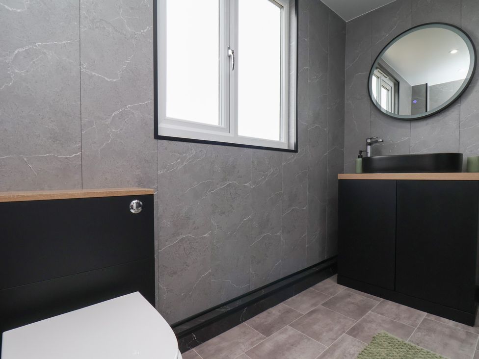 A bathroom featuring a sink, toilet, and a window at Sea View House in Marske-By-The-Sea