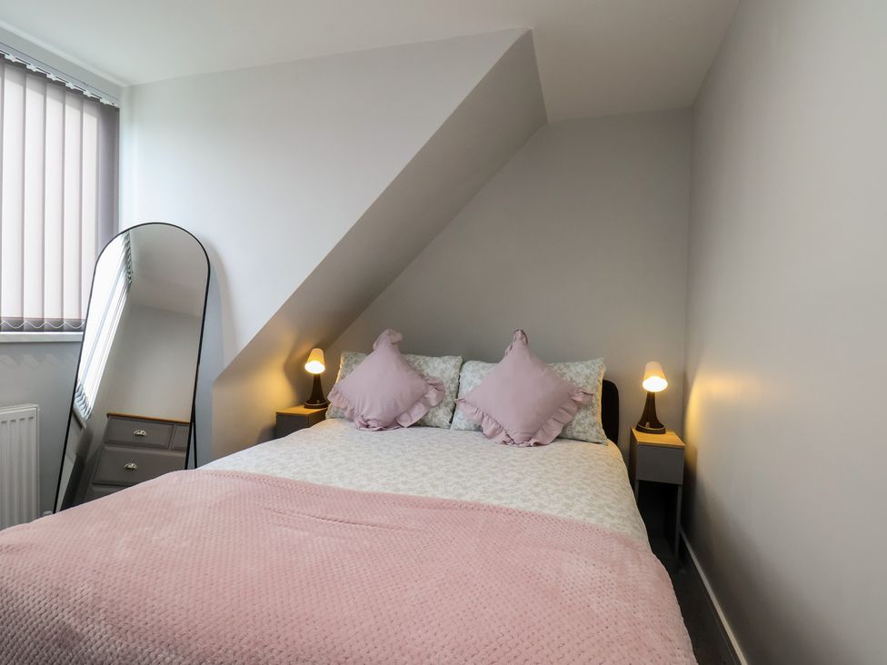 A bedroom with a bed and mirror at Sea View House in Marske-By-The-Sea