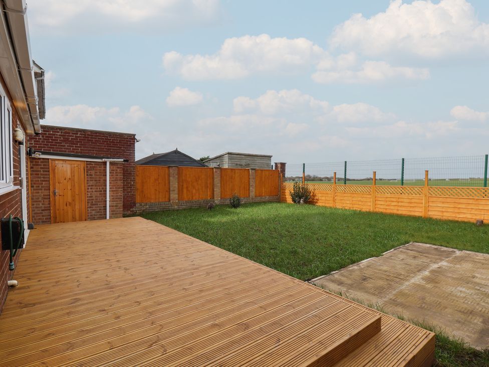 An outdoor area with wooden decking and fence at Sea View House in Marske-By-The-Sea