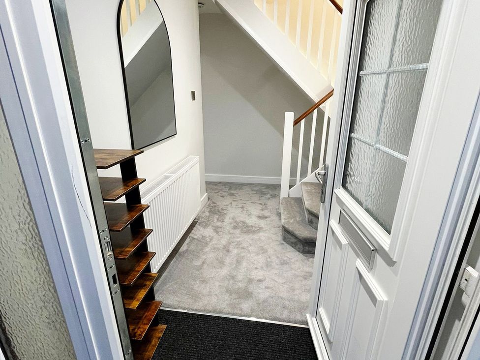 A hallway with a staircase and mirror at Sea View House in Marske-By-The-Sea