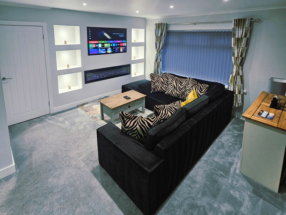 A living room with a sofa, coffee table, and television at Sea View House in Marske-By-The-Sea