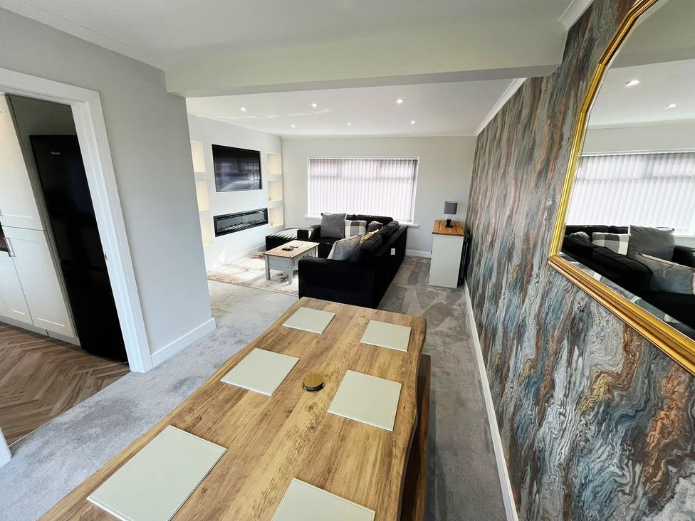 A living room with a sofa and a dining table at Sea View House in Marske-By-The-Sea