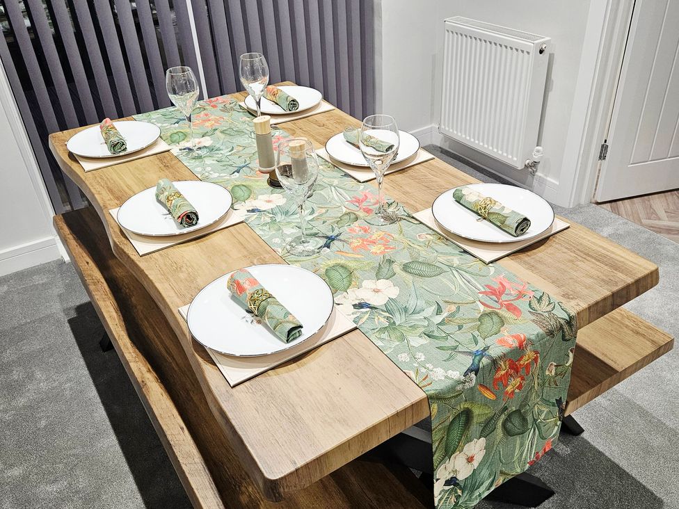 A dining room table set with plates and glasses at Sea View House Marske-By-The-Sea