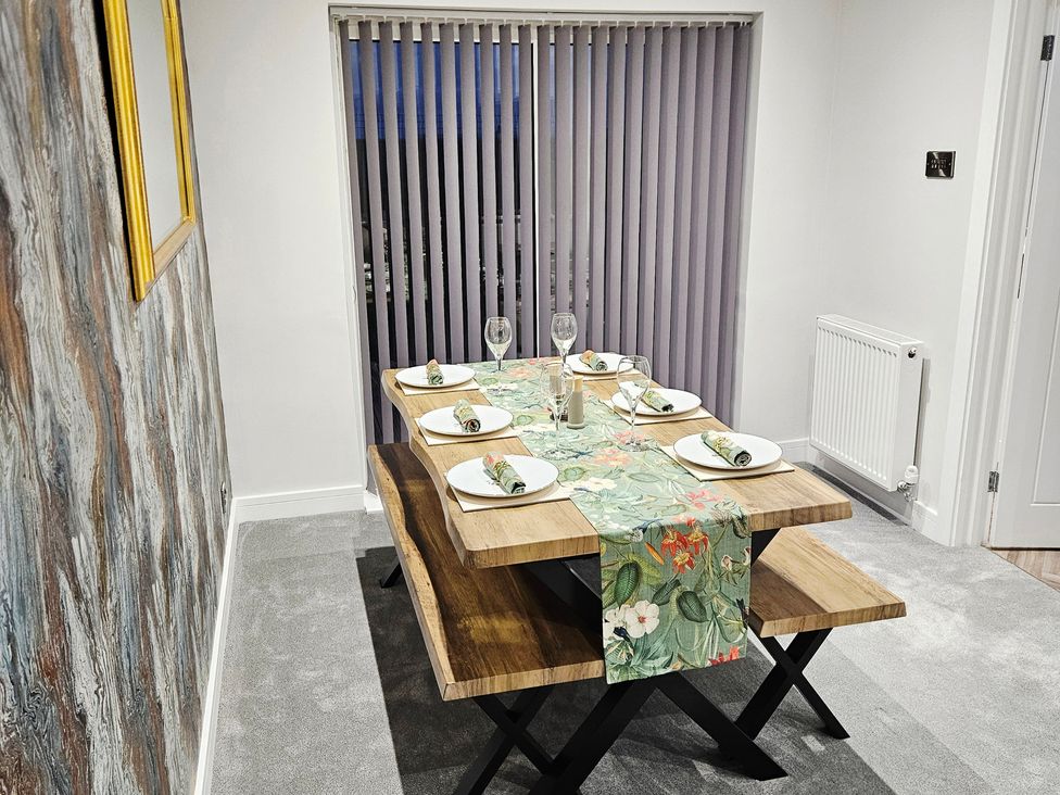 A dining table set with plates and glasses at Sea View House in Marske-By-The-Sea