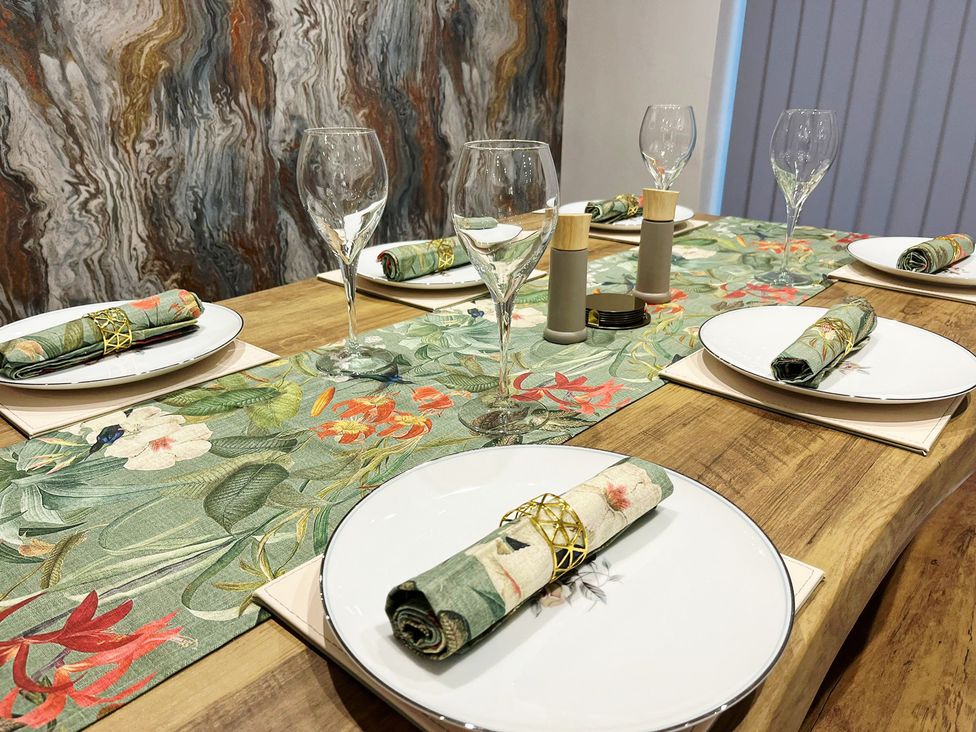 A dining room table set with plates and glasses at Sea View House in Marske-By-The-Sea