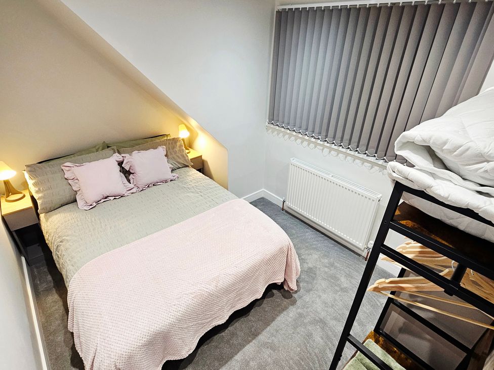 A bedroom with a bed and shelving unit at Sea View House in Marske-By-The-Sea