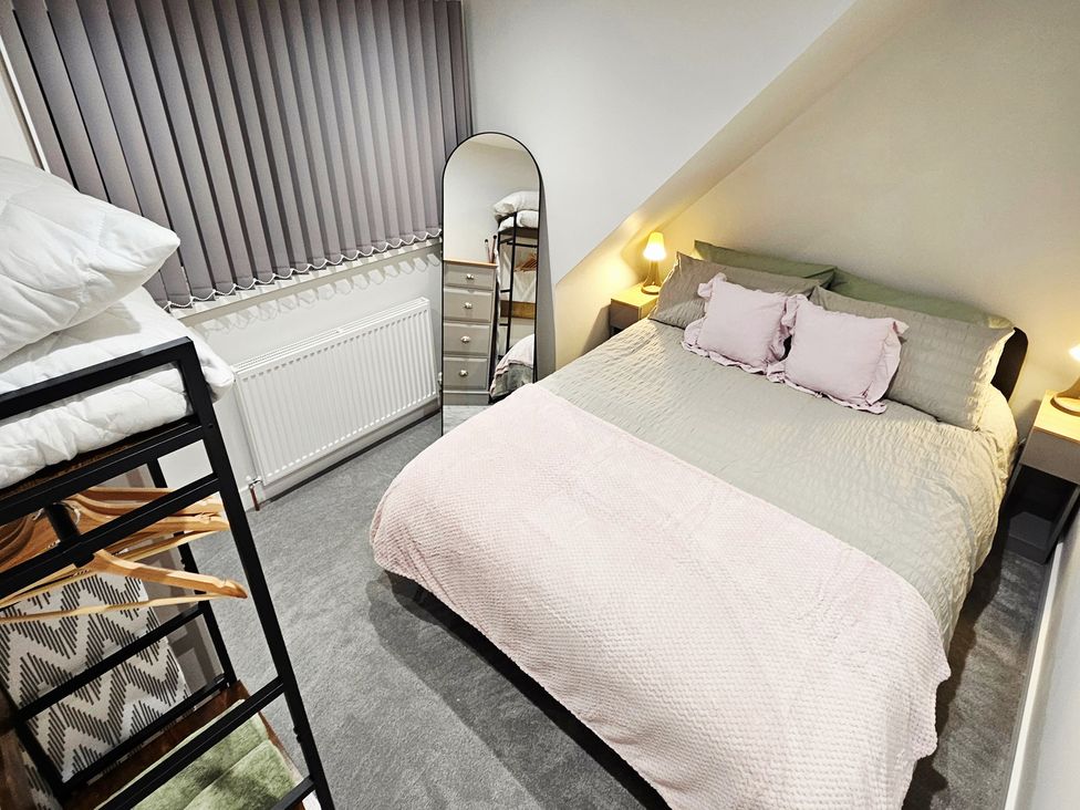 A bedroom with a bed, mirror, and dresser at Sea View House, Marske-By-The-Sea
