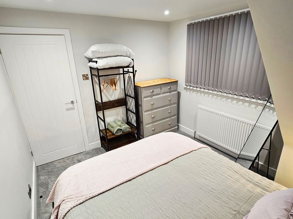 A bedroom with a bed and shelves at Sea View House in Marske-By-The-Sea