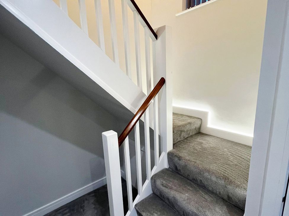 A staircase with handrail and carpet at Sea View House in Marske-By-The-Sea