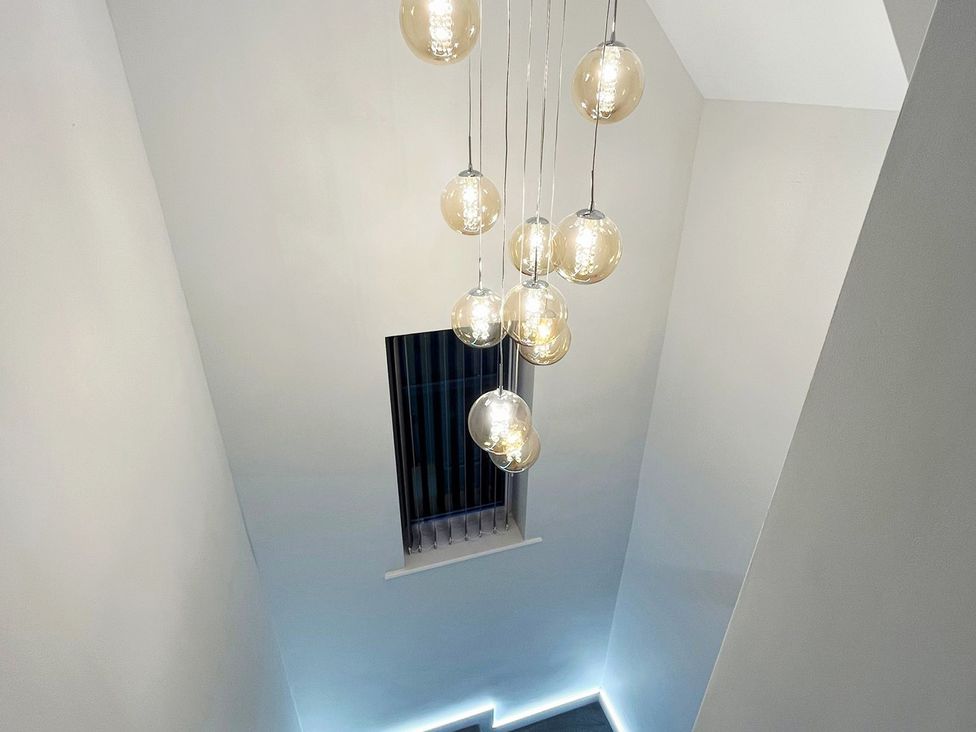 A staircase with modern light fixtures and a window at Sea View House Marske-By-The-Sea