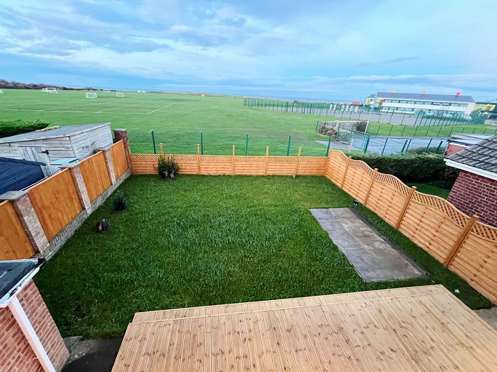 A garden with a wooden fence and grass at Sea View House in Marske-By-The-Sea