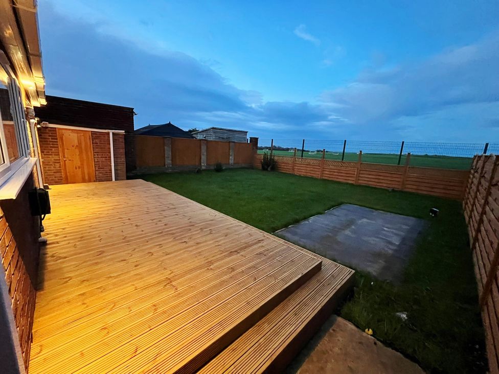 A garden with decking and grass at Sea View House in Marske-By-The-Sea