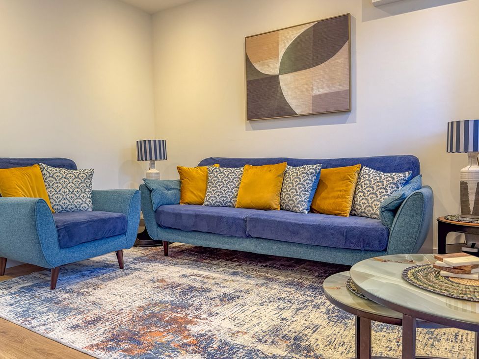 A living room with a sofa and armchair at 4 Bryn Heulog in Wrexham