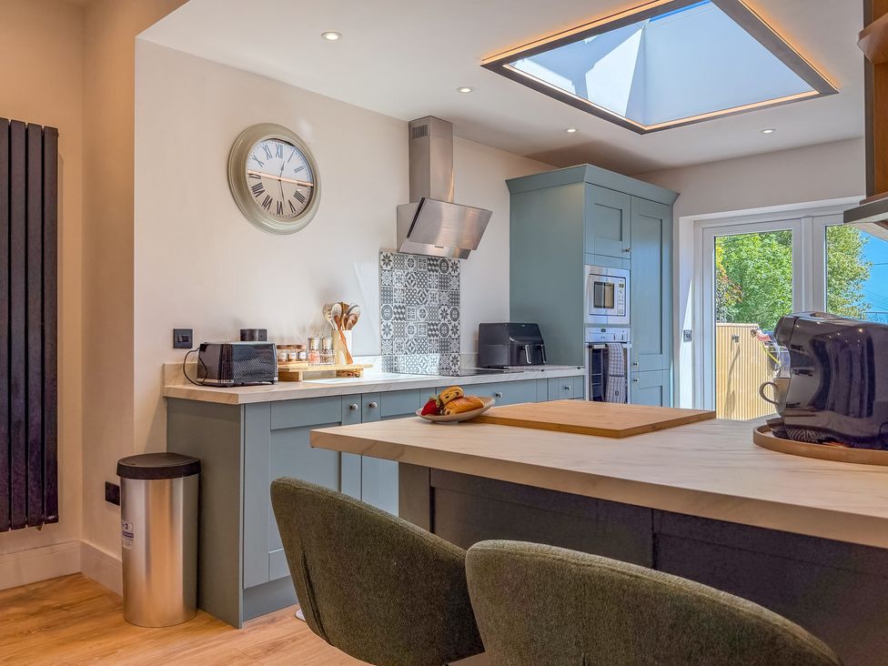 A kitchen with appliances and a skylight at 4 Bryn Heulog in Wrexham
