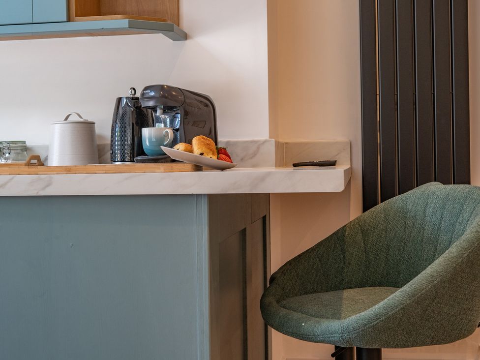 A kitchen counter with a coffee machine and snacks at 4 Bryn Heulog in Wrexham