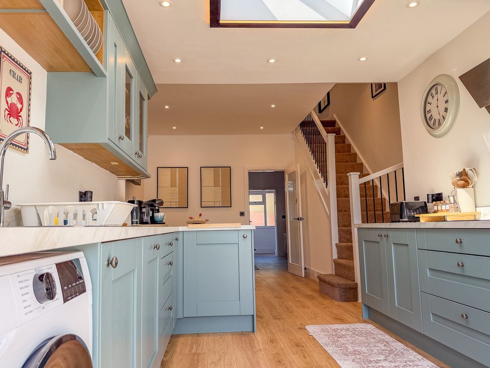 A kitchen with cabinets and a washer at 4 Bryn Heulog in Wrexham