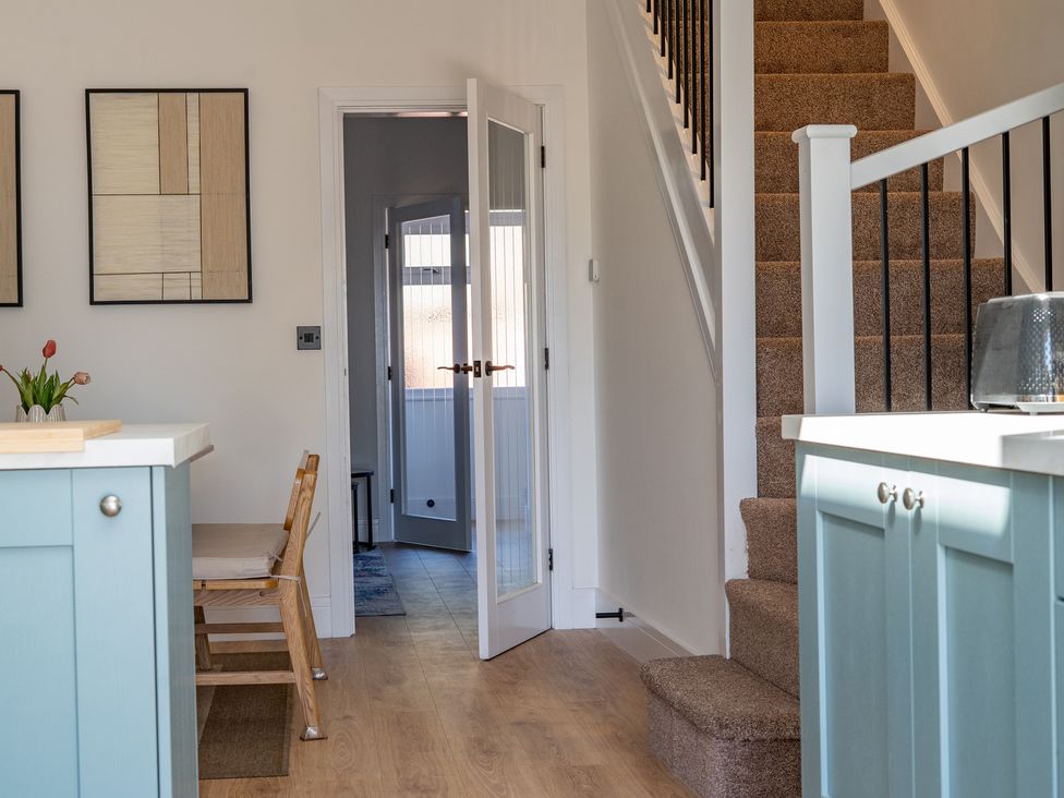 A kitchen with a staircase and dining table at 4 Bryn Heulog in Wrexham