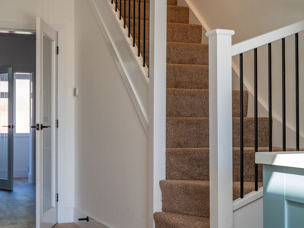 A hallway with stairs and a door at 4 Bryn Heulog, Wrexham