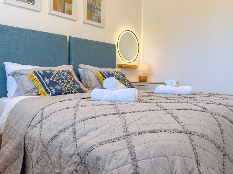 A bedroom with two beds and a lamp at 4 Bryn Heulog in Wrexham