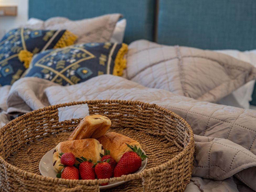 A bedroom with a tray of pastries and strawberries at 4 Bryn Heulog in Wrexham