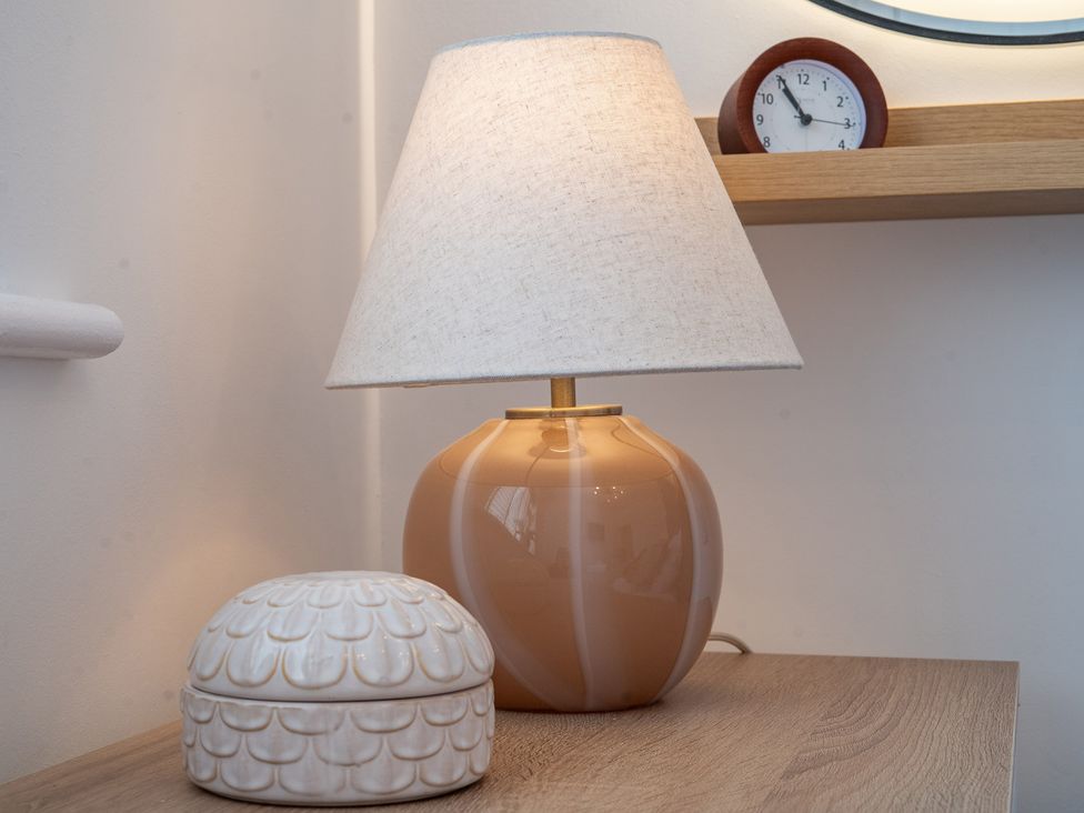 A lamp and clock on a shelf in a living room at 4 Bryn Heulog Wrexham