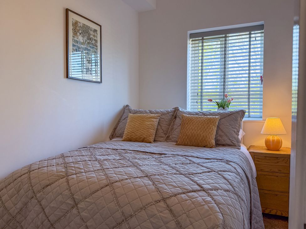 A bedroom with a bed and nightstand at 4 Bryn Heulog in Wrexham
