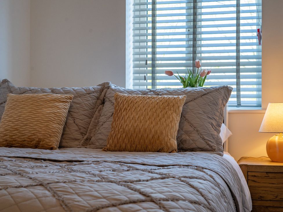 A bedroom with a bed and pillows at 4 Bryn Heulog in Wrexham