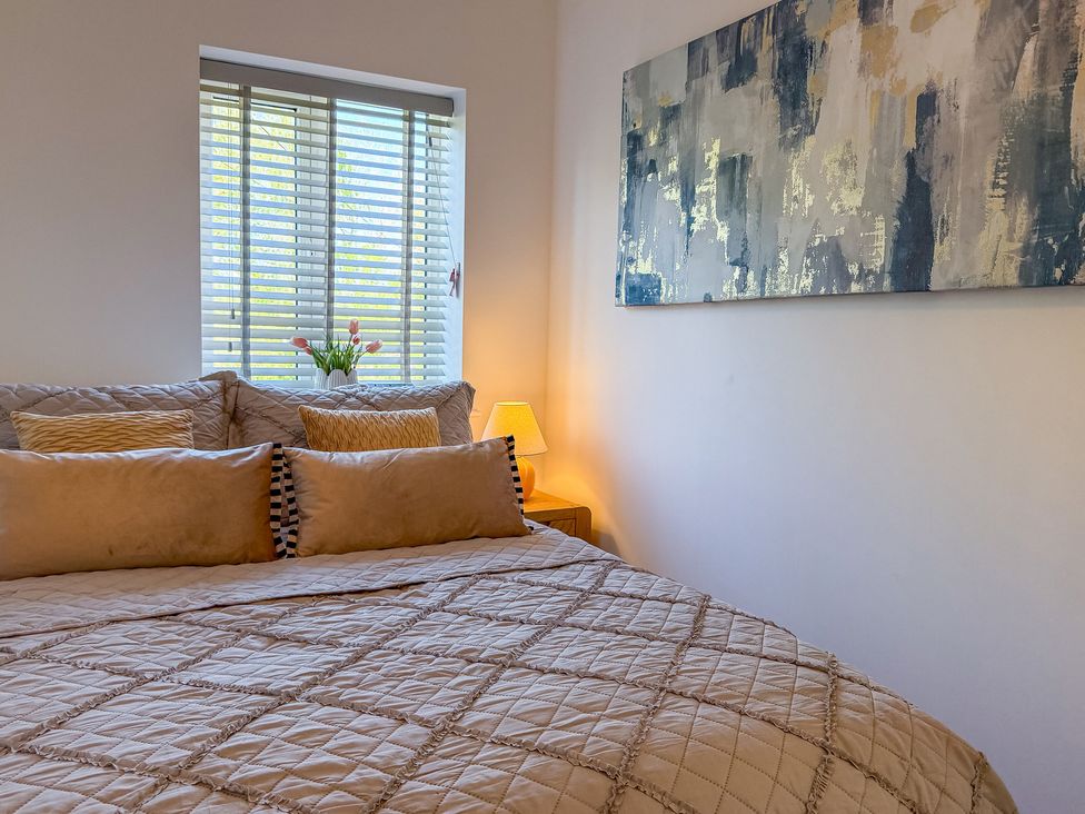 A bedroom with a bed and a lamp at 4 Bryn Heulog in Wrexham