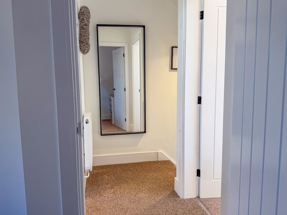A hallway with a mirror on the wall at 4 Bryn Heulog in Wrexham