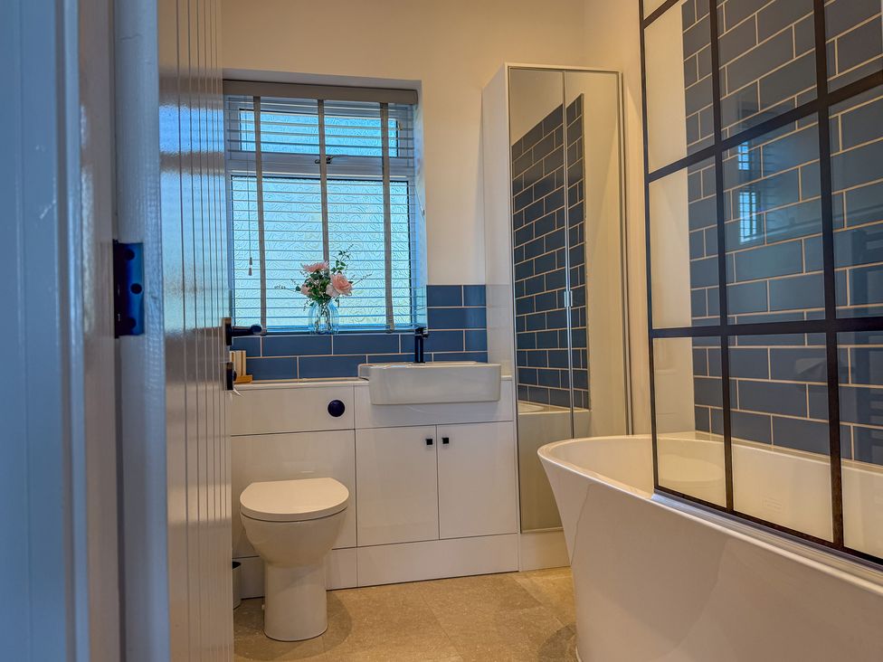 A bathroom with a sink, bathtub, and toilet at 4 Bryn Heulog in Wrexham