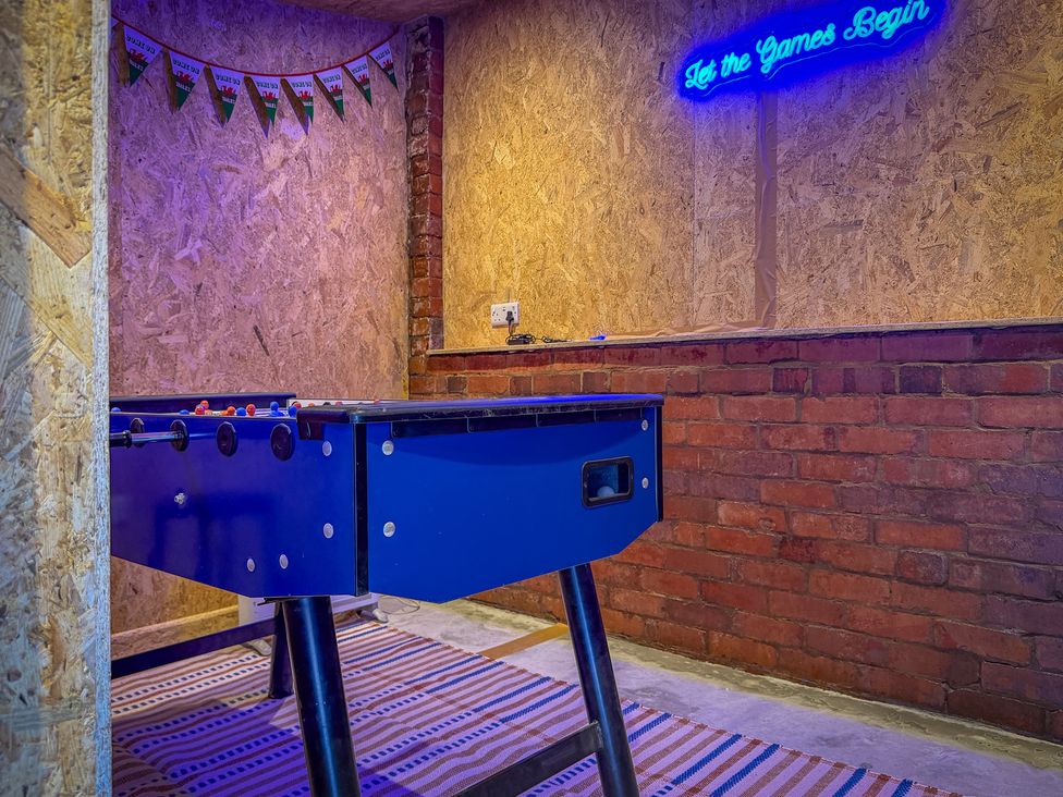 A games room with a foosball table and bunting at 4 Bryn Heulog in Wrexham
