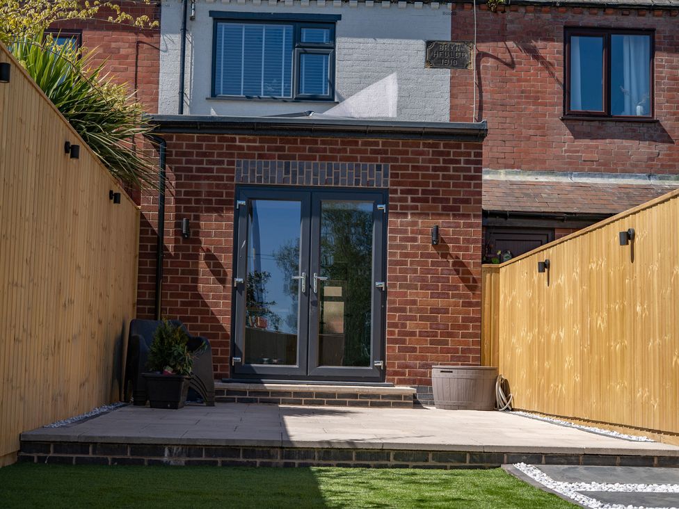 An outdoor garden with a brick wall and plants at 4 Bryn Heulog in Wrexham