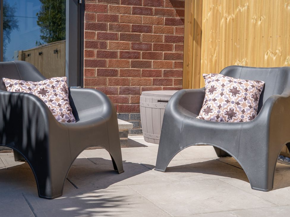 A seating area with chairs and pillows at 4 Bryn Heulog in Wrexham