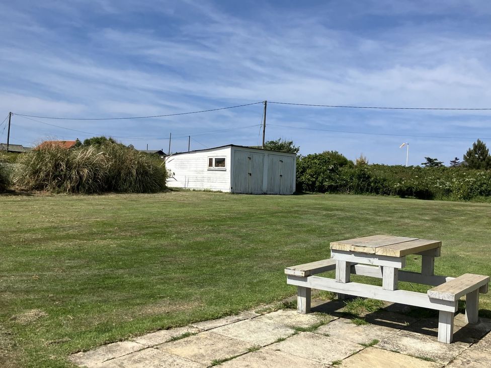 A garden with a table and a shed at Seadrift Bush Estate near Happisburgh
