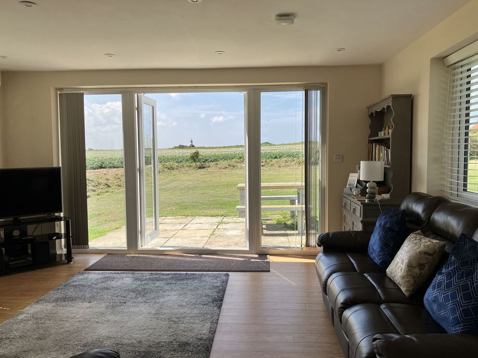 A living room with a sofa and television at Seadrift Bush Estate near Happisburgh