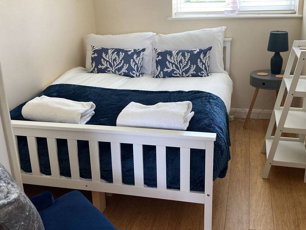 A bedroom with a bed and side table at Seadrift Bush Estate near Happisburgh