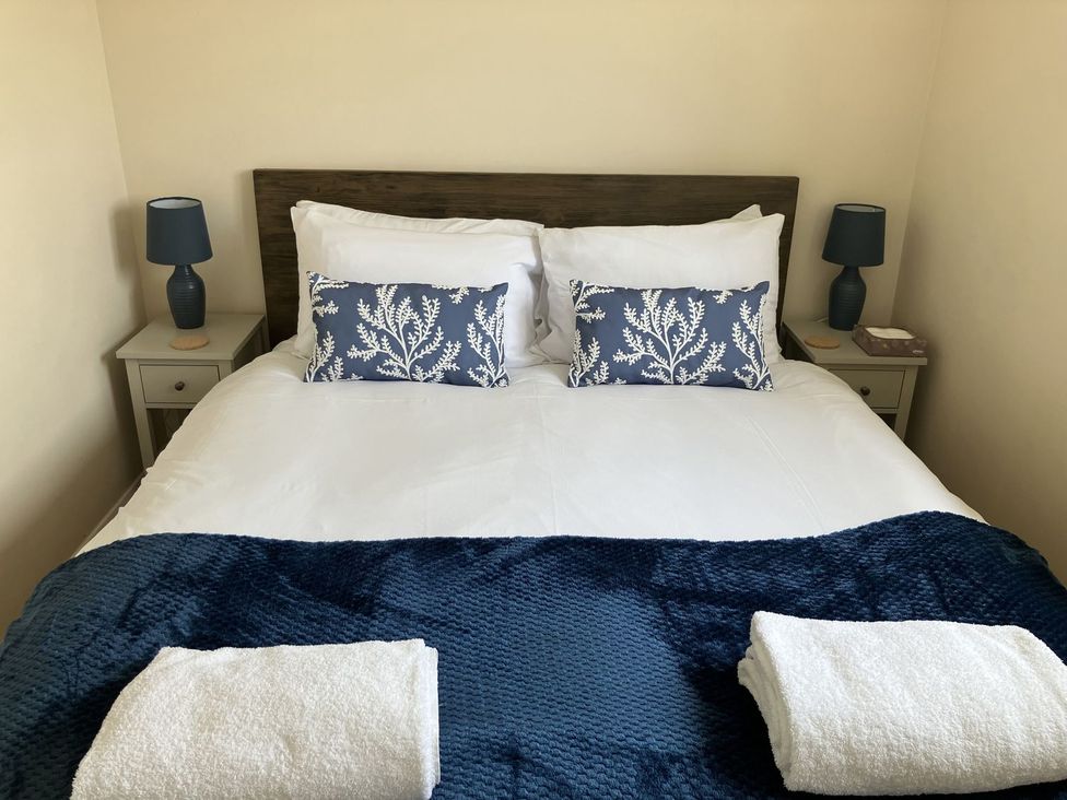 A bedroom with a bed and nightstand at Seadrift near Happisburgh