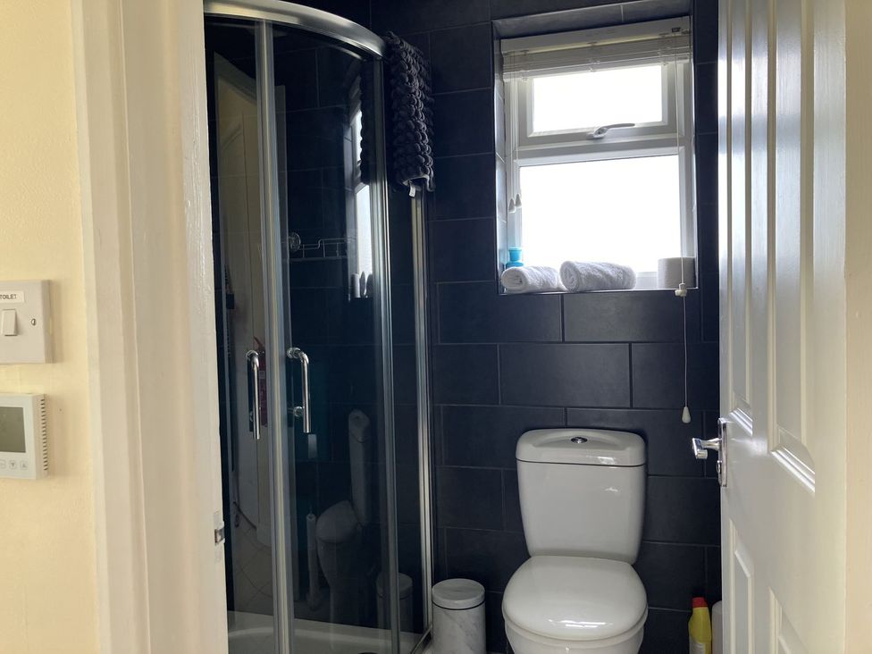 A bathroom with a shower and toilet at Seadrift in Bush Estate near Happisburgh