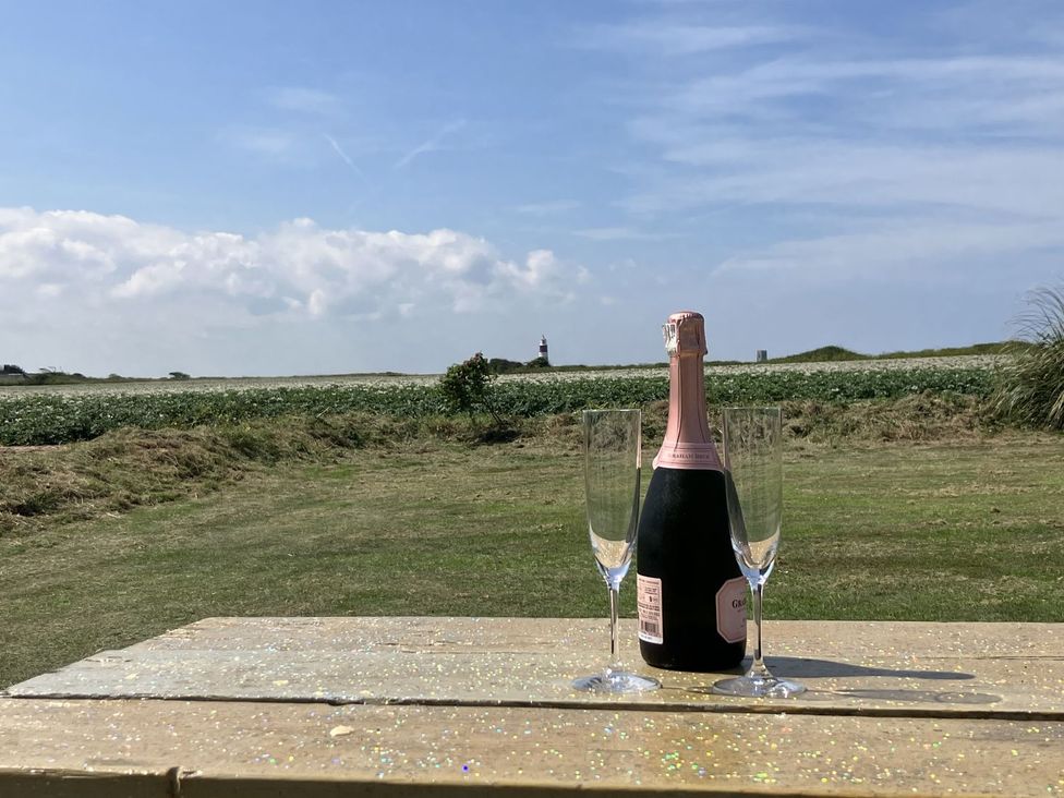 A champagne bottle and glasses on a table in an outdoor area at Seadrift near Happisburgh