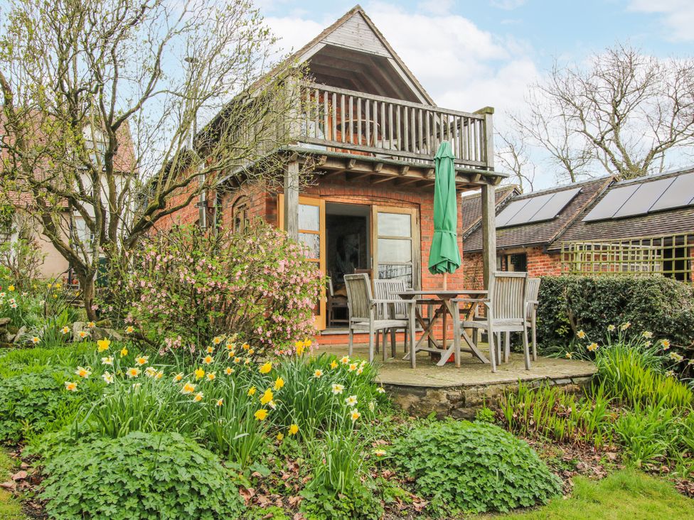 A garden with a house and furniture at Bell House Cottage in Wistanstow near Craven Arms