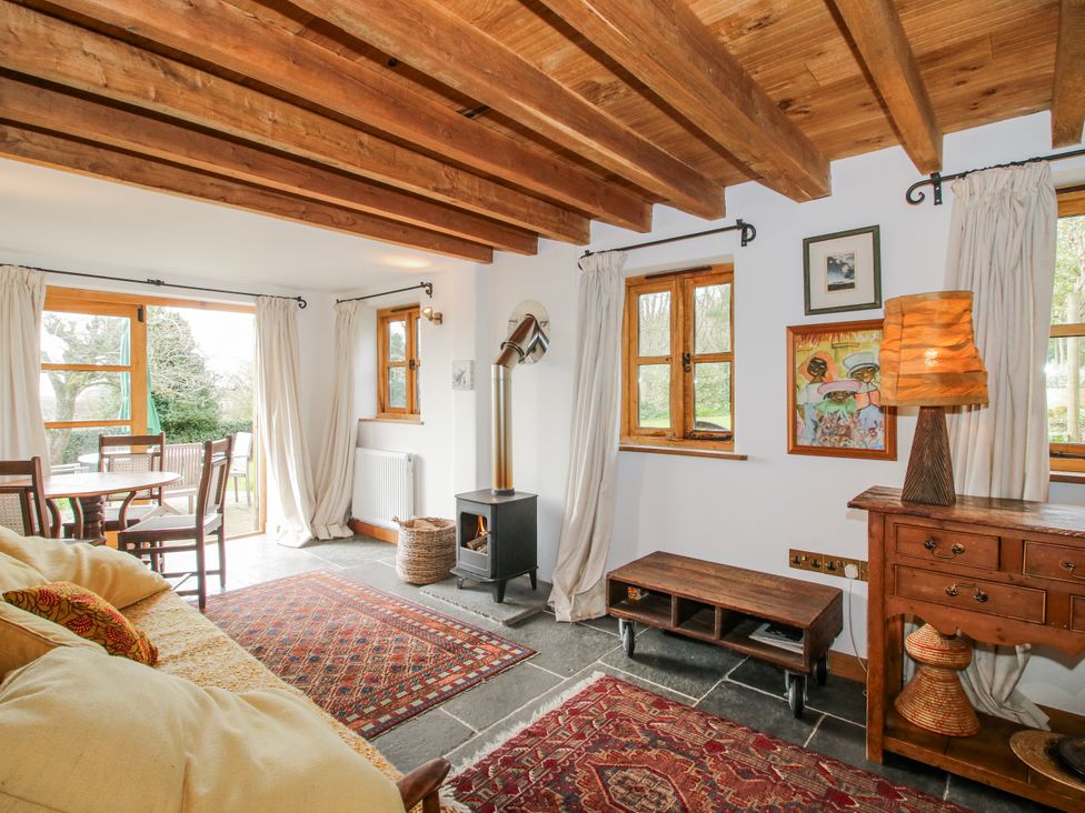 A living room with seating and a table at Bell House Cottage Wistanstow near Craven Arms