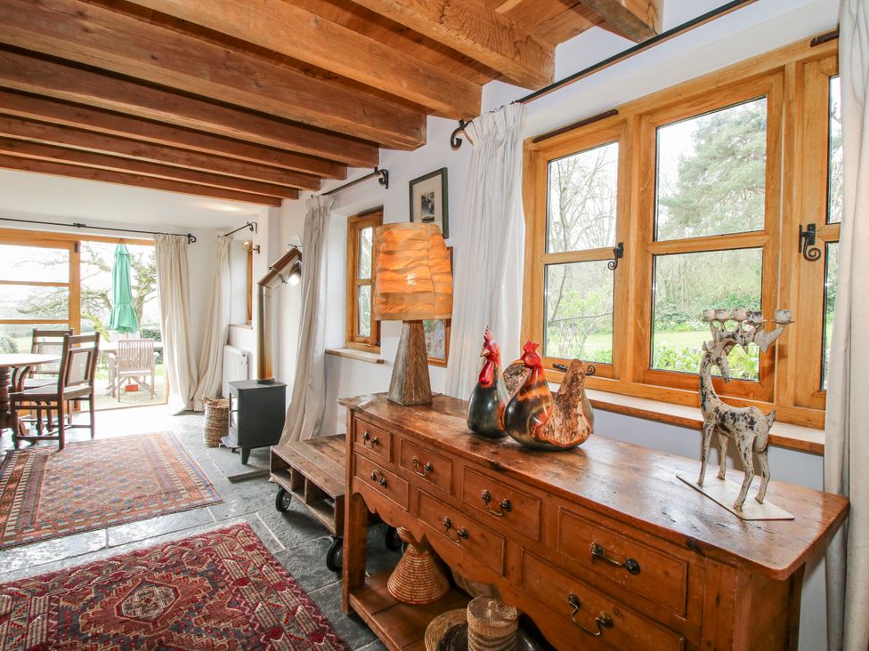 A living room with a wooden table and decorative items at Bell House Cottage in Wistanstow near Craven Arms