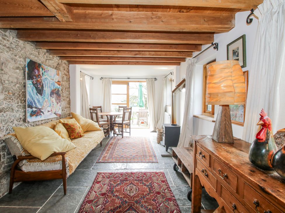 A living room with a sofa and dining area at Bell House Cottage Wistanstow near Craven Arms