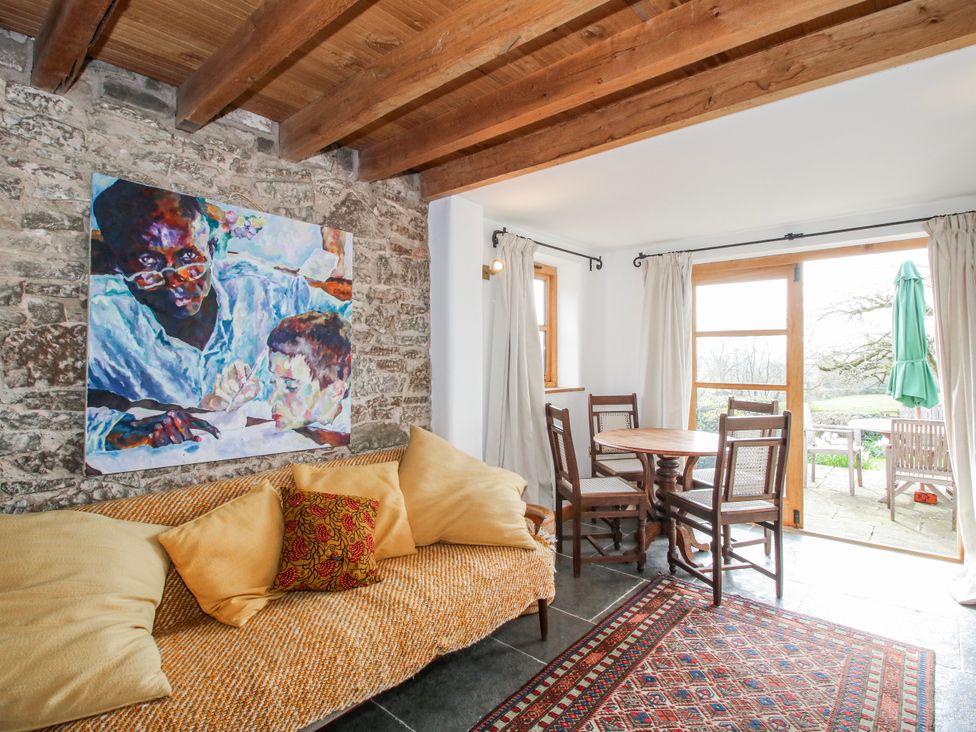 A living room with a painting and dining table at Bell House Cottage Wistanstow near Craven Arms