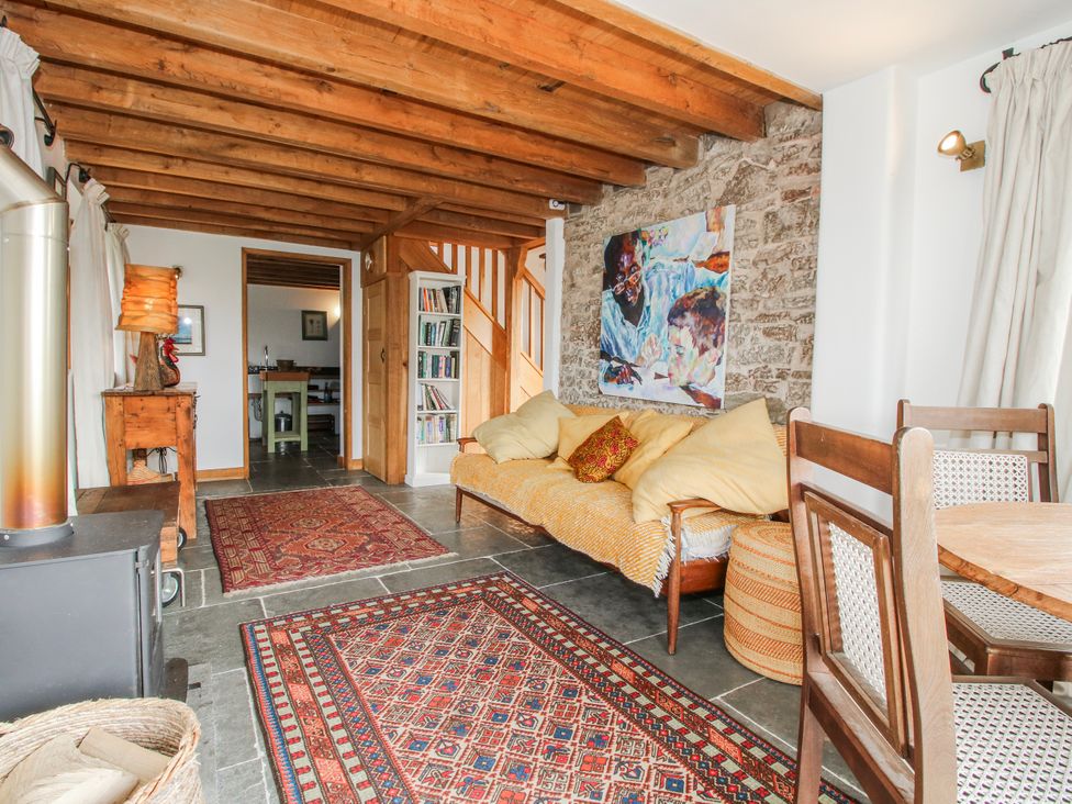 A living room with a sofa and dining area at Bell House Cottage in Wistanstow near Craven Arms