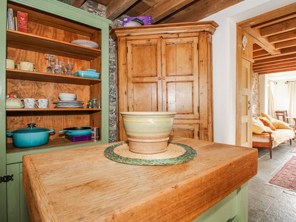 A kitchen with wooden cabinets and a table featuring a bowl at Bell House Cottage Wistanstow near Craven Arms