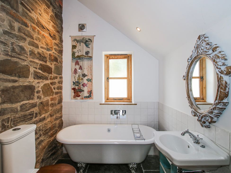 A bathroom with a bathtub and wash basin at Bell House Cottage in Wistanstow near Craven Arms