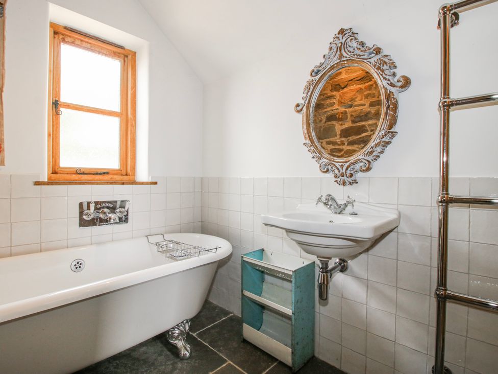 A bathroom with a bathtub and sink at Bell House Cottage in Wistanstow near Craven Arms