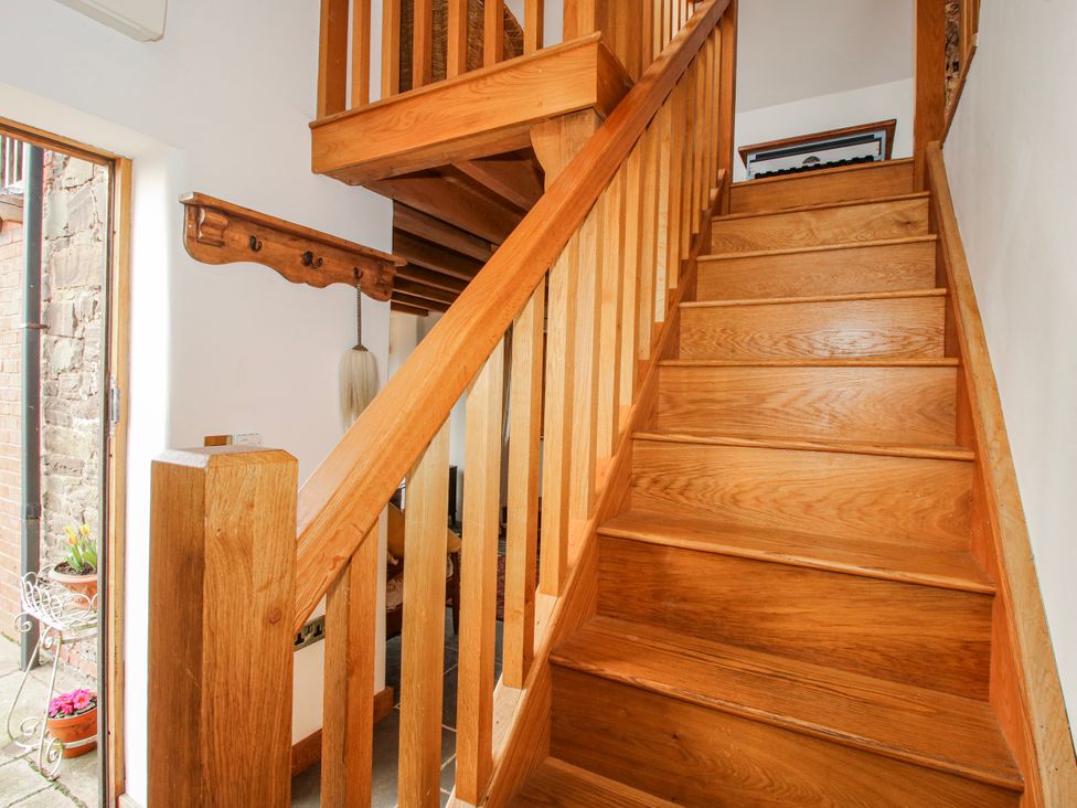 A staircase and coat hook in the hallway at Bell House Cottage in Wistanstow near Craven Arms